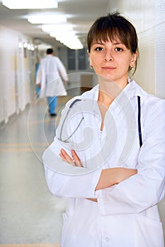 Female doctor in corridor under lamps