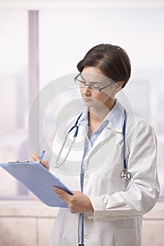 Female doctor doing paperwork in hospital