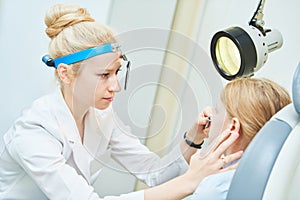 Female doctor of ENT ear nose throat at work examining girl nose