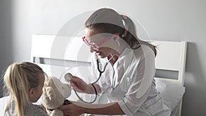 A female doctor examines a little girl in the hospital