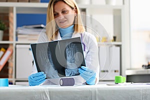 Female doctor examines an x-ray of patient leg