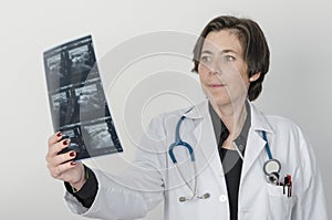 Female doctor examining accurately a x-ray.