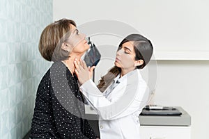 Female Doctor Examining Elderly Patient In Clinic