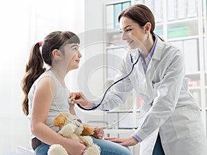 Female doctor examining a girl with a stethoscope