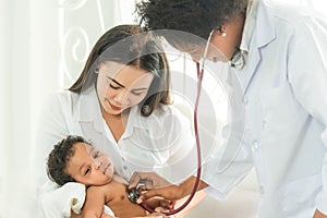 Female doctor examining kid little child boy