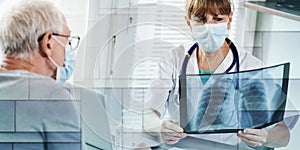 Female doctor examining lungs x-ray of senior man patient during coronavirus outbreak, geometric pattern