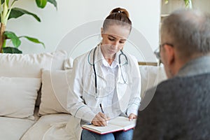 Female doctor examining older senior man in doctor office or at home. Old man patient and doctor have consultation in