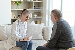 Female doctor examining older senior man in doctor office or at home. Old man patient and doctor have consultation in