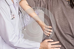 Female doctor examining a patient suffering from back pain