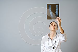 Female doctor examining x-ray image of legs of newborn baby
