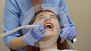 Female doctor examining a young girl`s teeth in the dental office.