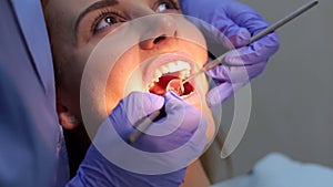 Female doctor examining a young girl`s teeth in the dental office.