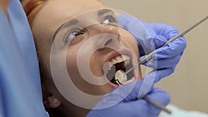 Female doctor examining a young girl`s teeth in the dental office.