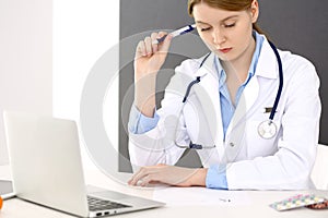 Female doctor filling up medical form on clipboard closeup. Physician finishing up examining his patient in hospital an