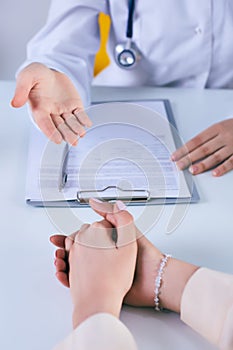 Female doctor giving a consultation to a patient and explaining medical informations and diagnosis. Just hands over the