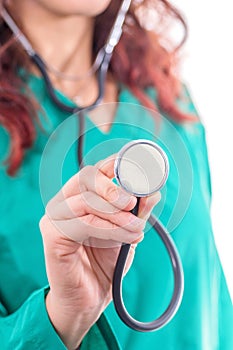 Female doctor in green lab coat holding stethoscope