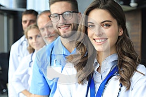 Female doctor with group of happy successful colleagues