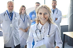 Female doctor with group of happy successful colleagues