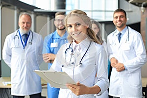 Female doctor with group of happy successful colleagues