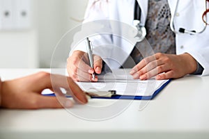 Female doctor hand hold silver pen filling patient history list