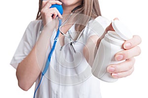 Female doctor hand holding phone and recipient of pills