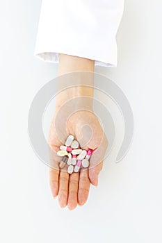 Female doctor hand holding pills and capsules, pharmaceutical treatment concept