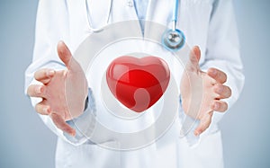 Female doctor hands holding a red heart