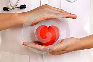 Female doctor hands holding a red heart shape