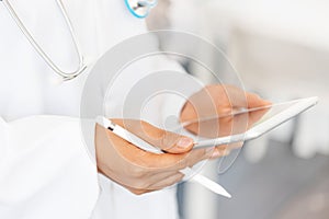 Female doctor` hands holding tablet computer and pen, use of electronic device in modern healthcare