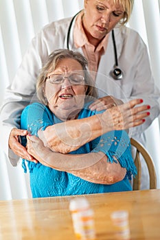 Female Doctor Helping Senior Adult Woman With Arm Exercises