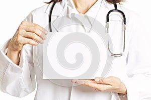 Female doctor holding a blank poster board with both hands. Health concept