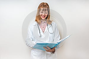 Female doctor holding blue clipboard and reading something