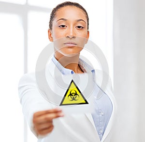 Female doctor holding boihazard caution sign