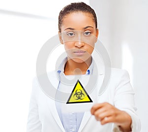 Female doctor holding boihazard caution sign