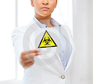 Female doctor holding boihazard caution sign