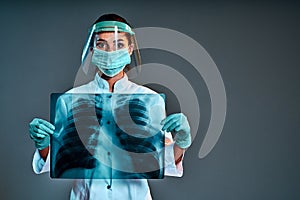 Female doctor holding chest x-ray isolated on dark gray background