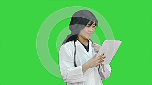 Female doctor holding digital tablet presenting project looking at camera on a Green Screen, Chroma Key