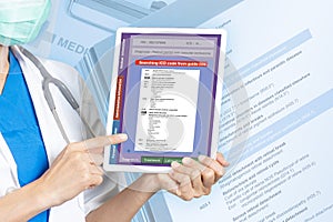 Female doctor holding digital tablet showing search result of ICD-10 code photo