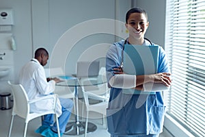 Female doctor holding file and smiling in the hospital