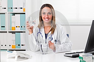 Female doctor holding a glass of water