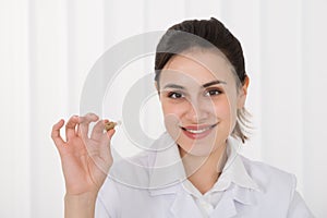 Female Doctor Holding Hearing Aid