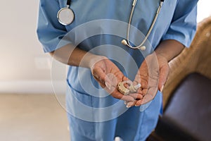 Female doctor holding hearing aid machine at home