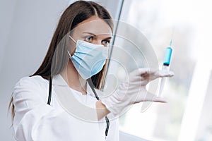 Female doctor holding medical injection syringe and stethoscope.Biological hazard.