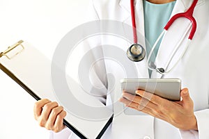 Female doctor holding patient medical chart and tablet computer