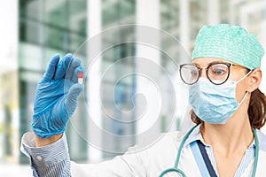 Female doctor holding a pill in hand. Doctor presents a medicine and treatment