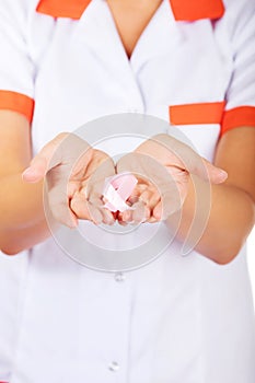 Female doctor holding pink breast cancer awareness ribbon