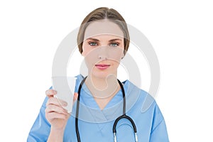 Female doctor holding a plastic cup and looking into the camera