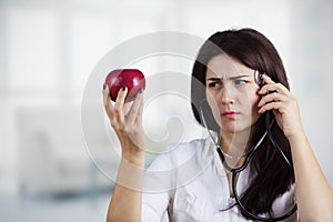 Female doctor holding red apple