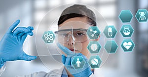 Female doctor holding tablet with medical interface hexagon icons