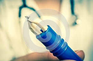 Female doctor is holding tweezers with a tick - retro style